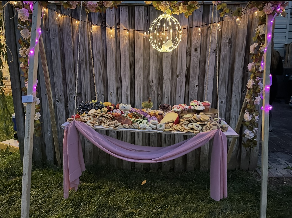 Hanging charcuterie swing table with florals and fairy lights