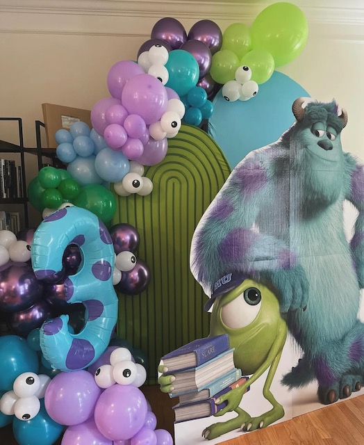 Monsters Inc themed balloon garland with Sulley and Mike cutouts