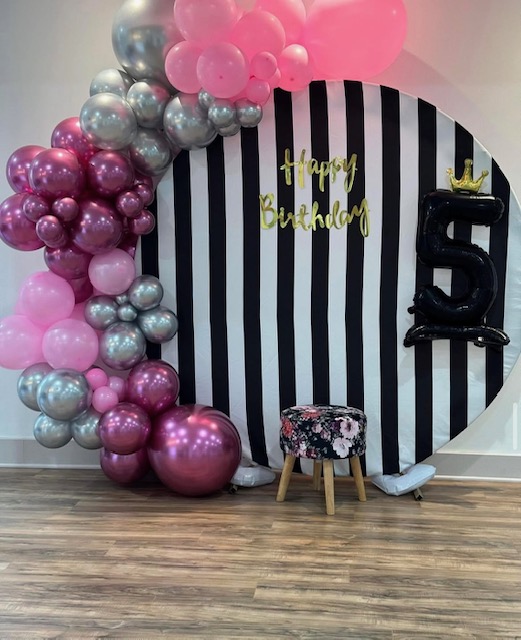 Pink and silver balloon garland with striped backdrop