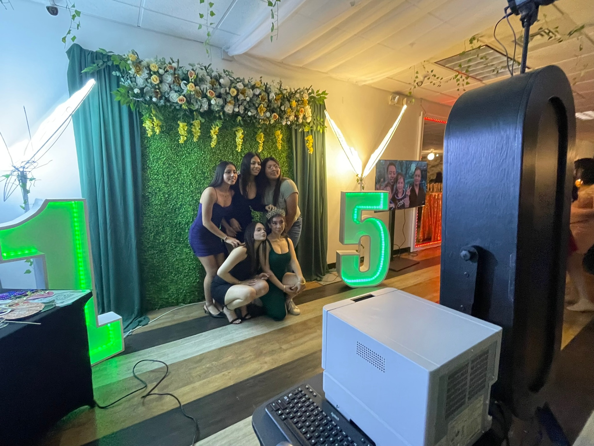 Quinceañera floral backdrop with marquee numbers and photo booth